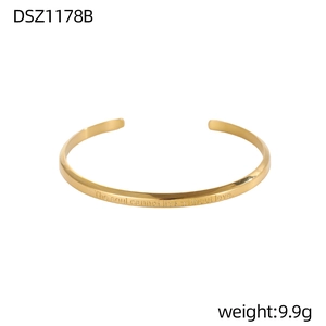Primer plano del brazalete dorado grabado con el texto The soul cannot live without love