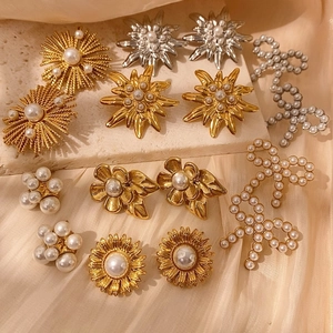 Pendientes vintage de flores en oro y plata con perlas sobre elegante seda suave