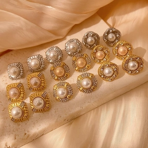 Elegantes pendientes de perlas vintage con marcos de pedrería sobre seda de champán