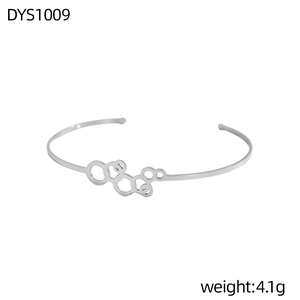 Detalle de una pulsera abierta plateada con un diseño geométrico de estructura molecular