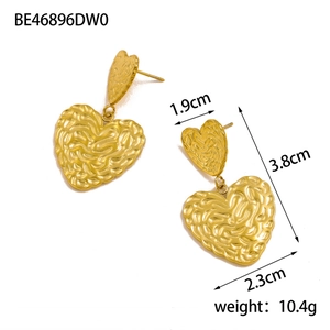 Detailed view of gold textured heart earrings with tiered design and hammered finish