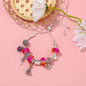 Makroaufnahme von Silber-Charm-Armband mit Eiffelturm-Herzanhänger und Glasperlen