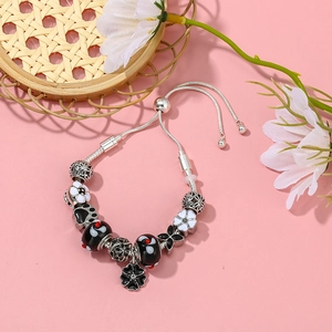Versilbertes Perlenarmband mit Traumfänger-Blumenanhänger auf rosa Hintergrund