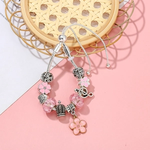 Detailansicht der versilberten DIY-Charm-Armbands mit rosa Kirschblüten und Krone