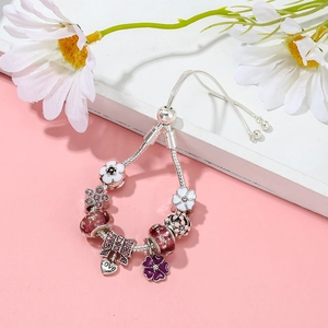 Versilbertes verstellbares Schlangenarmband mit Blumenperlen und einem Herzanhänger