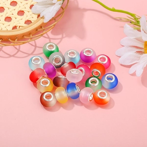 Assorted matte frosted glass large hole beads with silver metal cores on pink background