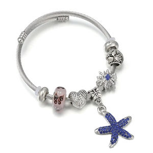 Détail du bracelet câble torsadé argenté avec pendentif étoile de mer et perles
