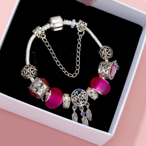 Silver Pandora-style charm bracelet with pink crystal butterfly and dreamcatcher pendant