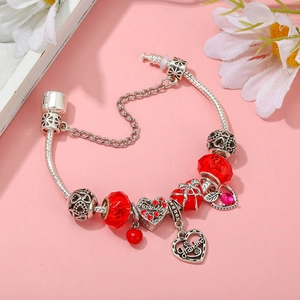 Detail of silver beaded bracelet featuring red heart charms and Family Grandma pendants