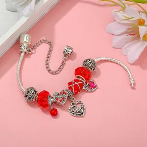 Detail of silver snake chain bracelet with red crystal beads and Grandma heart charms