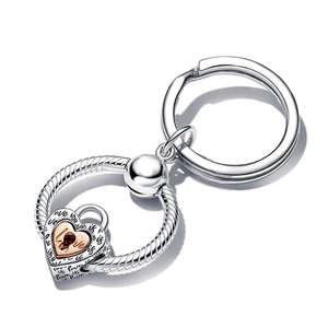 Macro detail of silver twisted ring keychain with rose gold heart padlock and Love engraving