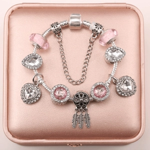 Pink dreamcatcher charm bracelet with crystal beads and heart pendants on leather box