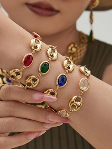Close-up of gold plated anchor link bracelets with colorful glass stones on female wrist