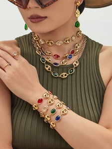 Close-up of vintage multi-layer gold plated jewelry set with colorful gemstone accents