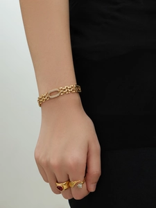 Détail d'un bracelet à maillons en plaqué or 18k serti de zircons sur le poignet d'une femme