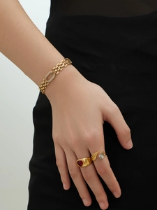 Détail du bracelet chaîne de montre plaqué or 18k et des bagues avec pierre de coeur