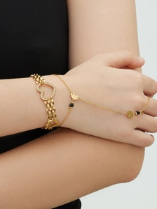 Detail of 18k gold plated heart hand chain with zirconia accents and black beads
