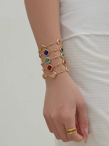 Detail of 18k gold plated bracelet with colorful faceted gemstones and hollow design ring