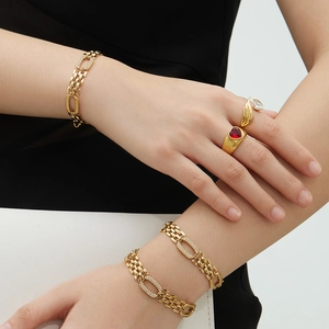 Bracelets à maillons dorés avec diamants et bague à pierre rouge en forme de cœur sur modèle