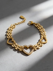 Detail of 18k gold plated stainless steel watch-link bracelet with zircon heart charms