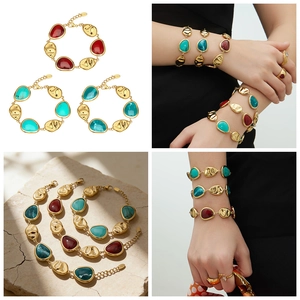 Detail van 18k vergulde armbanden met druppelvormige harsstenen en gehamerde textuur