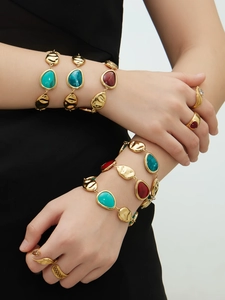 Detail van 18k vergulde armbanden met harsstenen en bijbehorende gouden ringen