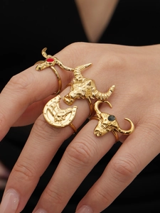 Dettaglio di quattro anelli in acciaio inossidabile placcati oro 18k con motivi a testa di toro