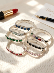 Dettaglio di bracciali in acciaio inossidabile con castoni di pietre di vetro colorate