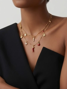 Détail d'un collier doré double rang avec piments et trèfles sur un mannequin