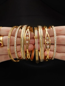 Detailopname van 18k vergulde armbandset met zirkonia en diverse geometrische patronen