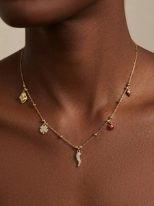Détail du collier plaqué or 18k avec pendentifs trèfle, cœur et coccinelle orné de zircons