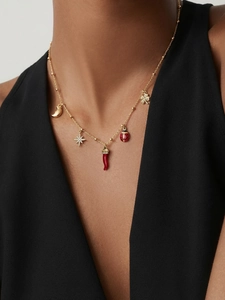Détail du collier plaqué or 18k avec pendentifs étoile en zircon et piment rouge