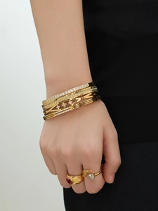 Detail van 18k vergulde armbanden met rode hartvormige edelsteen en ringen met druppelsteen
