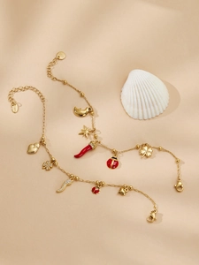 Détail des breloques trèfle et cornicello rouge sur un ensemble de bracelets dorés