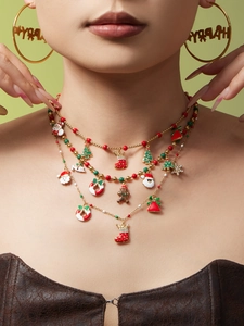 Detail van gelaagde gouden kerstketting met emaille Kerstman en Happy-oorbellen