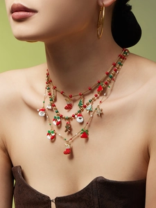 Detail van meerlaagse gouden ketting met kleurrijke kersthangers van emaille en zirkonia
