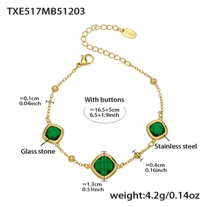 Detail view of a gold stainless steel bracelet with three square green glass stones and extender