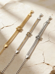 Dettaglio di bracciali intrecciati a più fili con nodo e placcatura in oro e argento