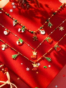 Detailweergave van feestelijke kerstkettingen met bedeltjes in een rode geschenkdoos