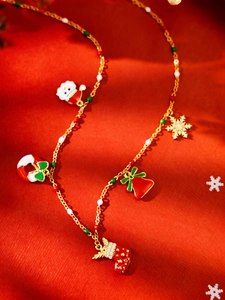 Detail van de kerstketting met kerstman, sneeuwvlok en bel aan een gouden schakelketting