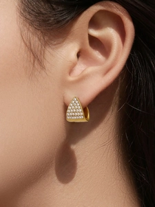 Dettaglio di orecchini a triangolo geometrico in placcatura oro 18k con zirconi incastonati