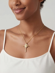 Dettaglio di una collana a croce placcata oro 18k con zirconi e medaglia di Maria sul modello