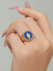 Détail macro d'une bague chevalière dorée avec émail bleu et relief de Marie