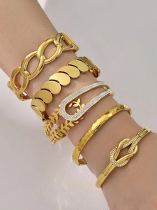 Detail von fünf 18k vergoldeten Armbändern mit Weizenmuster und Zirkonia am Handgelenk