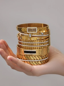 Detail of 7pcs gold plated stainless steel bangles set with zircon and geometric patterns