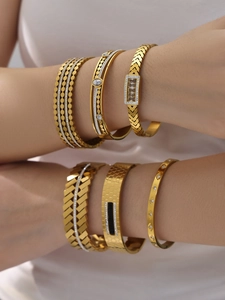 Macro shot of 18k gold plated stainless steel bangles with zircon and geometric details