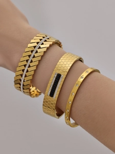Close-up of three 18k gold-plated geometric bangles with zircon inlay on wrist
