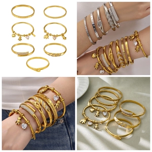 Macro shot of 18k gold plated stainless steel bangles with bear and heart charms