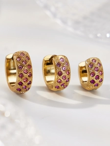 Detail van 18k vergulde huggie hoops met CNC-roosterstructuur en roze kristallen