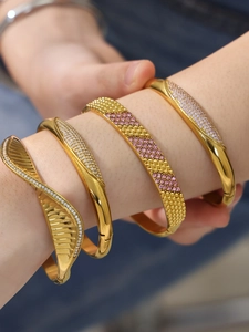 Detail of four 18k gold plated stainless steel bangles with sparkling zircon inlays